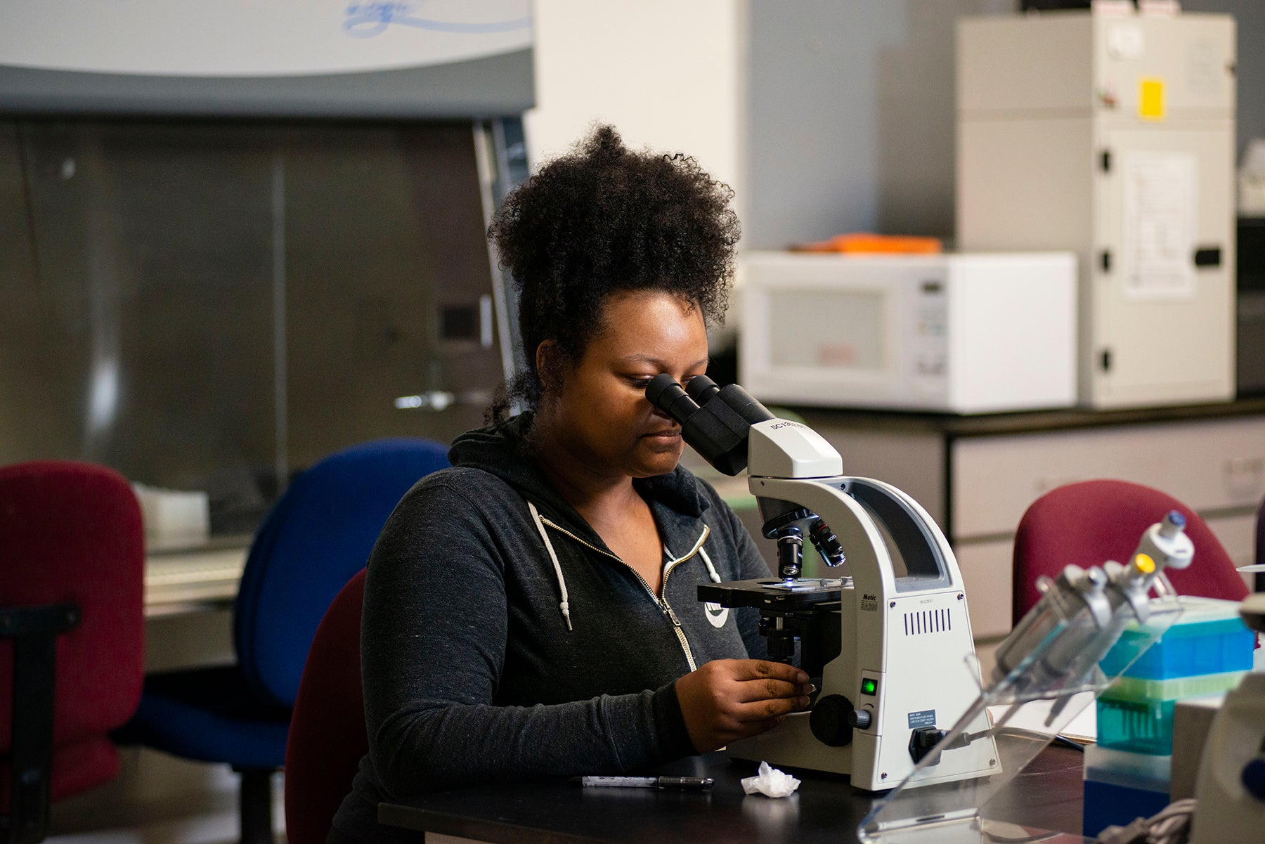 Student looking into microscope
