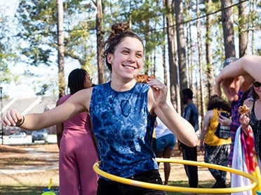 A student hula hoops while enjoying pizza during a student event on one of Georgia Southern's campuses