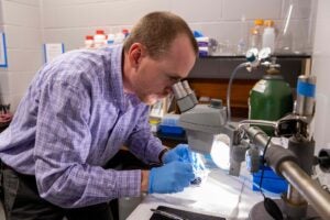 A man conducting an experiment with a microscope