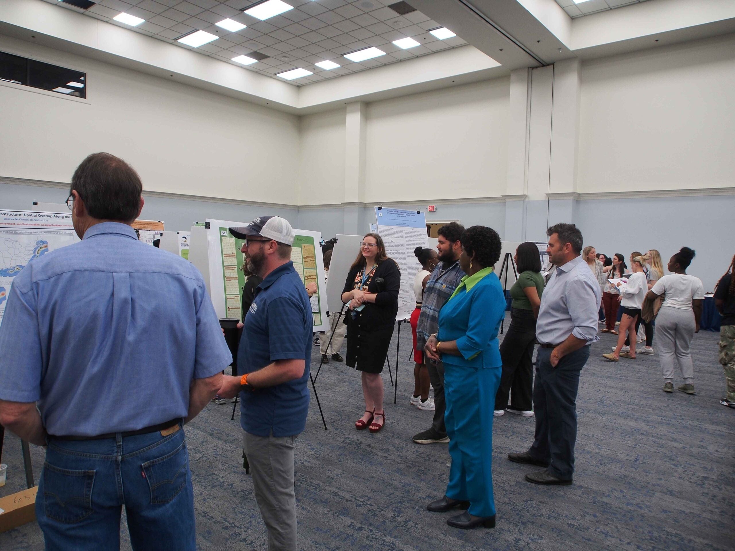 Symposium attendees viewing students' poster presentations on the Statesboro campus.