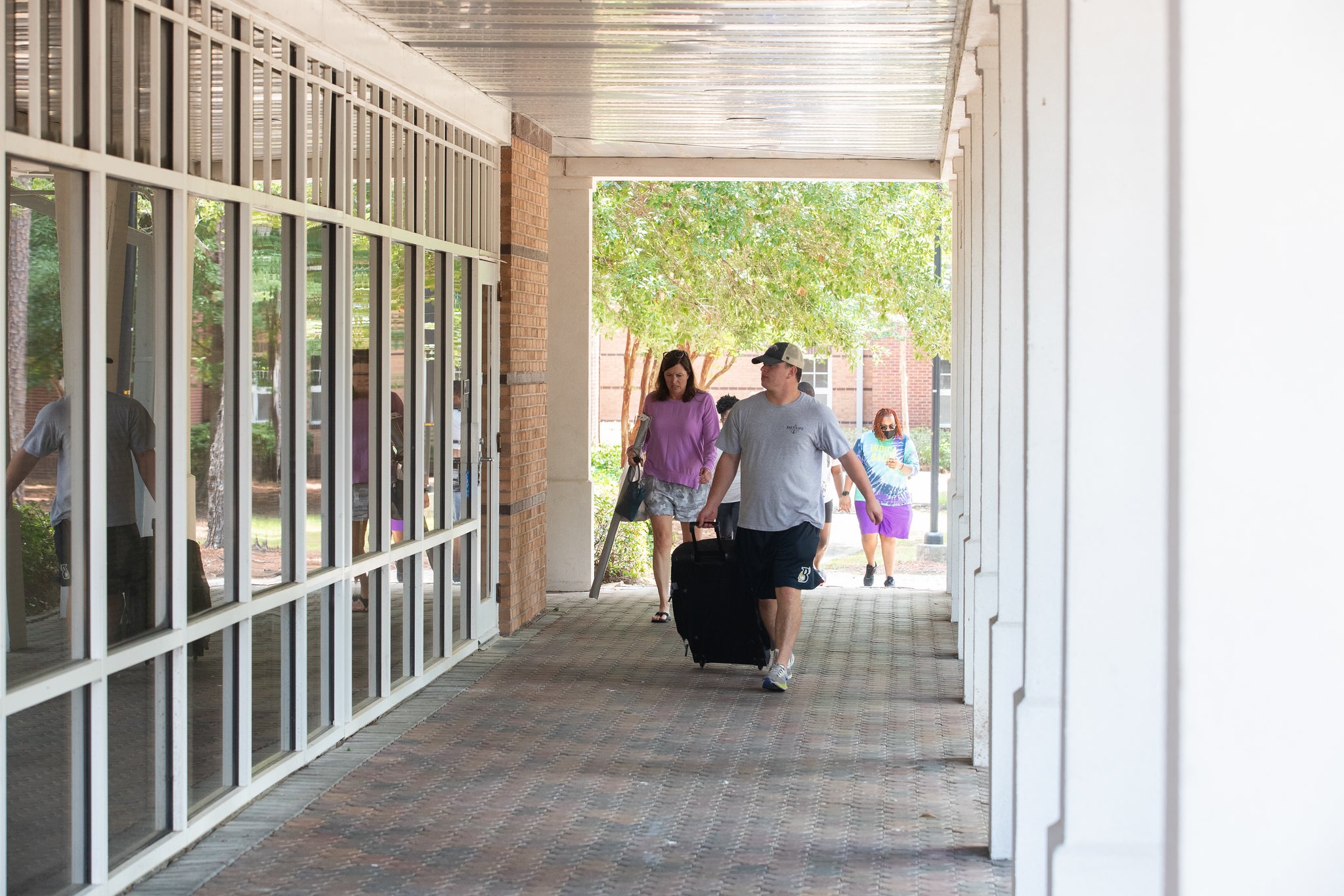 Student walking around the Georgia Southern campus with a suitcase.