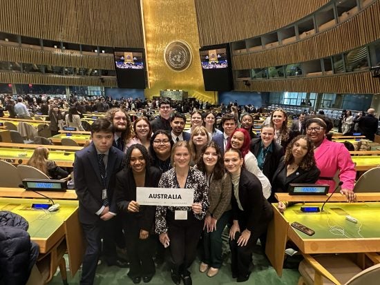 A group of students holding a sign that says Australia.