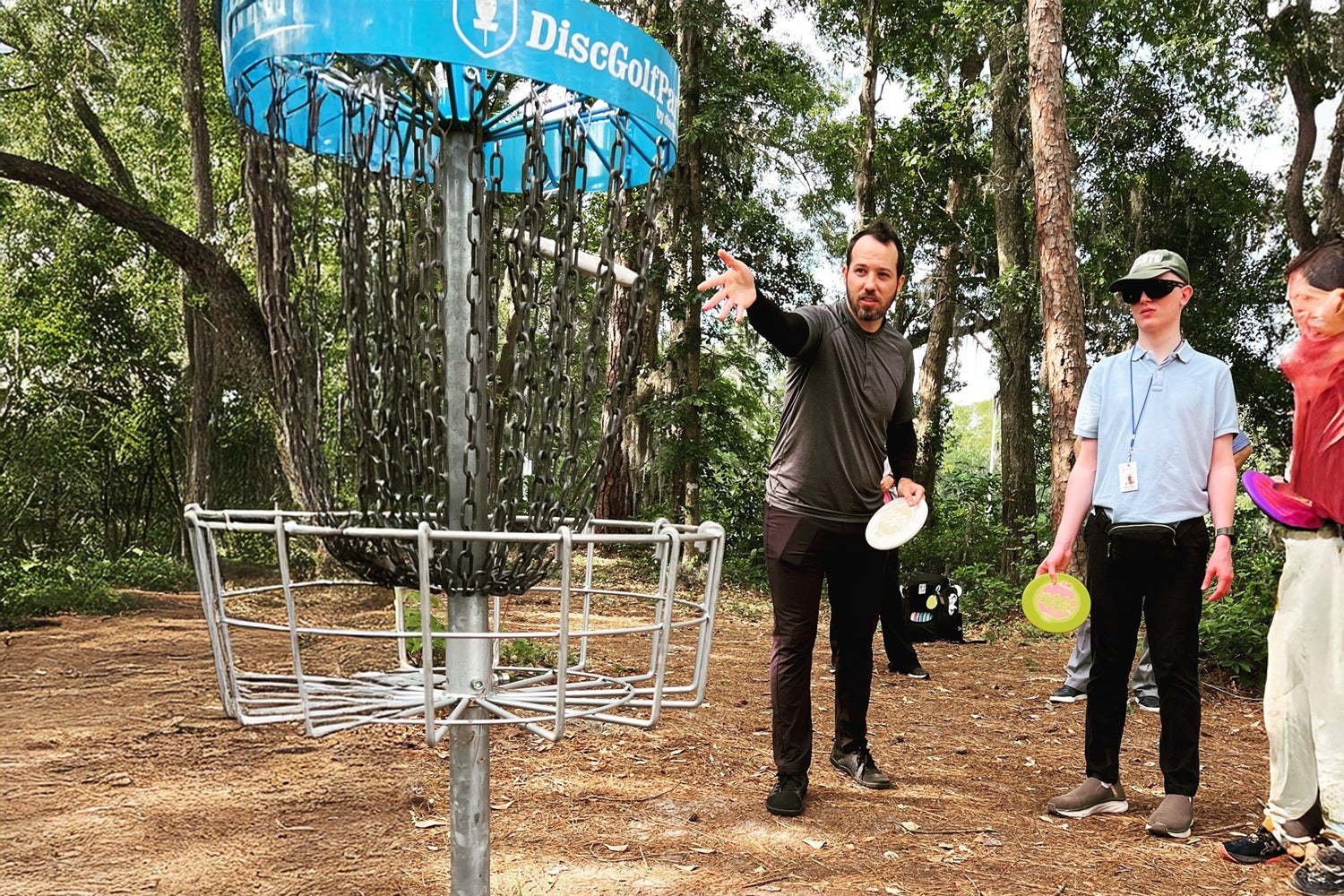A group of Georgia Southern students play frisbee golf on campus at the CRI disc golf course.