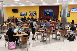 Georgia Southern students dine together in the meal hall with lots of tables and chairs.