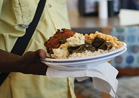A Georgia Southern student carries a plate of food back to the table in the dining hall for a delicious meal.