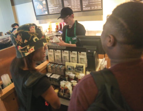 Customers wait in line to order at Starbucks coffee shop.