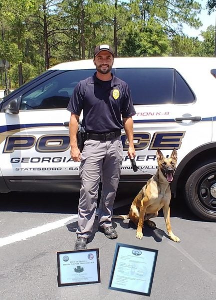 Georgia Southern Office of Public Safety officers BJ McKellar and K-9 Rocky pose with their certificates after completing trainings related to the new equipment they were recently donated.