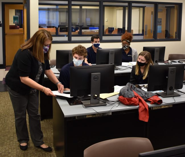 Senior lecturer in the School of Accountancy, Gloria Stuart, left, assists students as part of the Volunteer Income Tax Assistance program. 