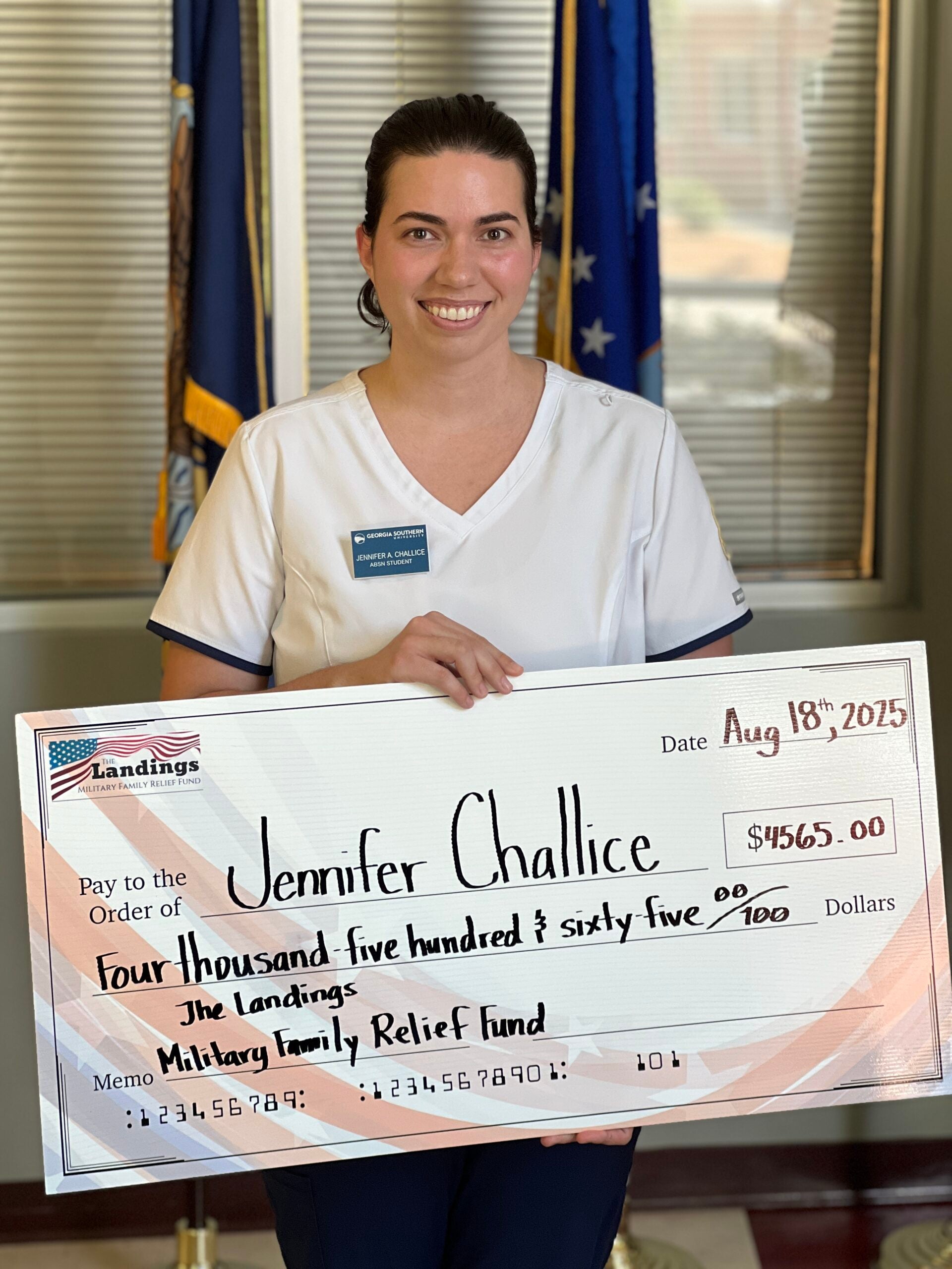Jennifer Challice receives a novelty check representing her scholarship from the Landings Military Family Relief Fund.
