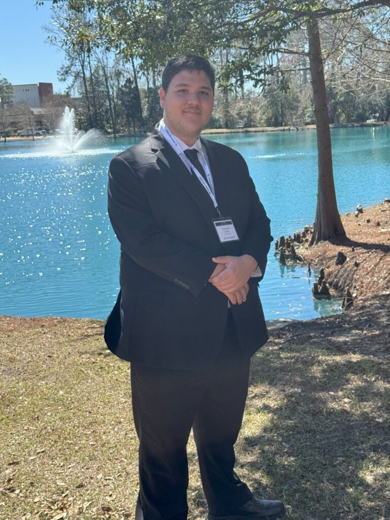 Pacheco stands in front of a fountain on the Statesboro Campus.