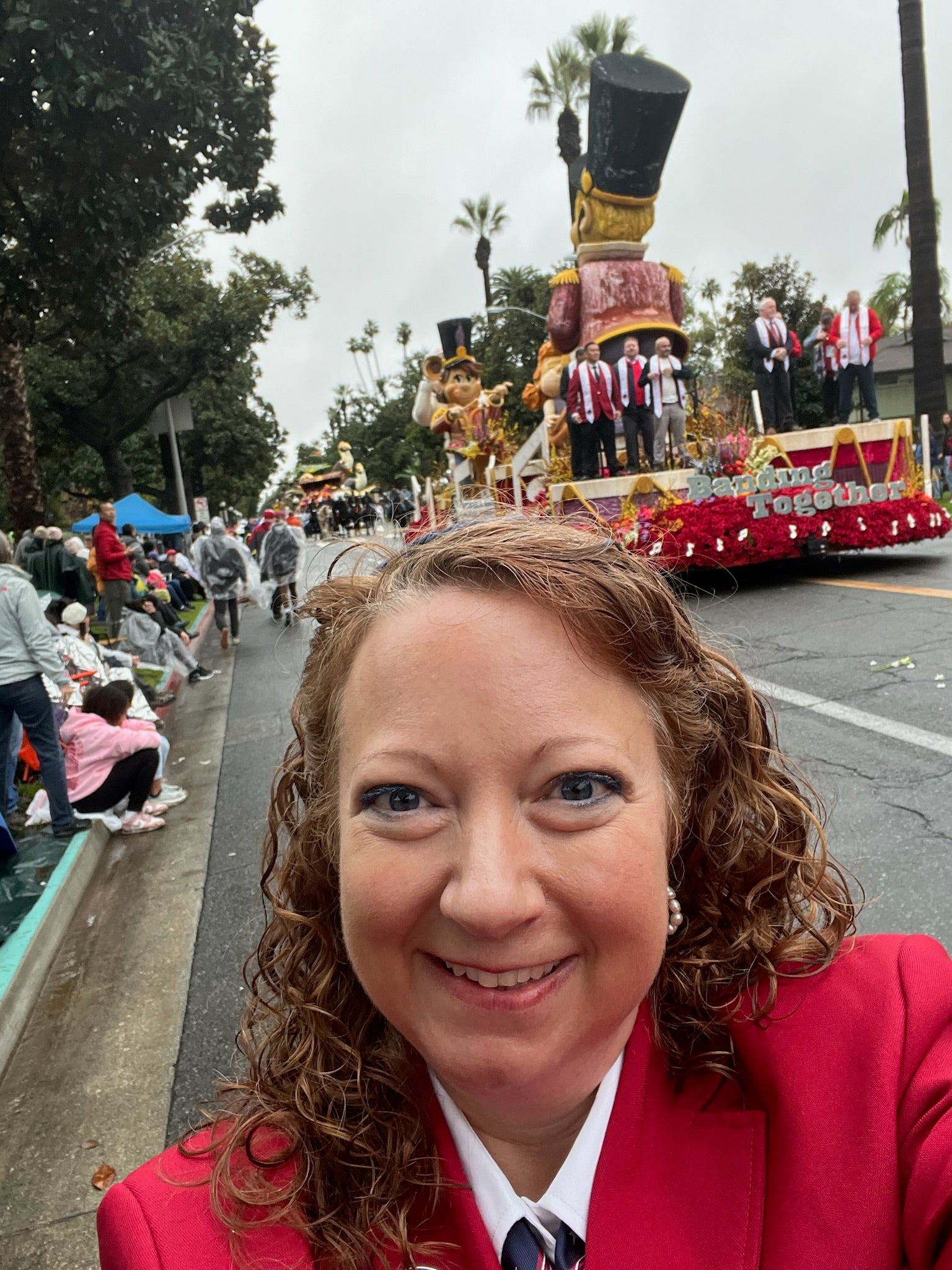 Georgia Southern alumna Joy Harden wears a red jacket posing in front of the Rose Parade's banding together float of 2026