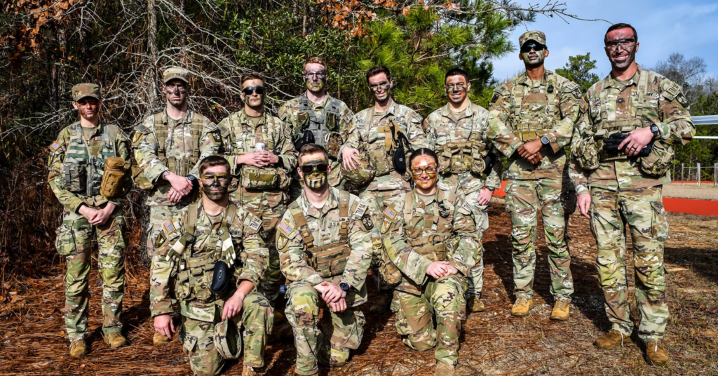 Georgia Southern's ROTC the Eagle Battalion poses for a group photo in camouflage fatigues. Eight people are standing and three are kneeling in front of the cadets standing.