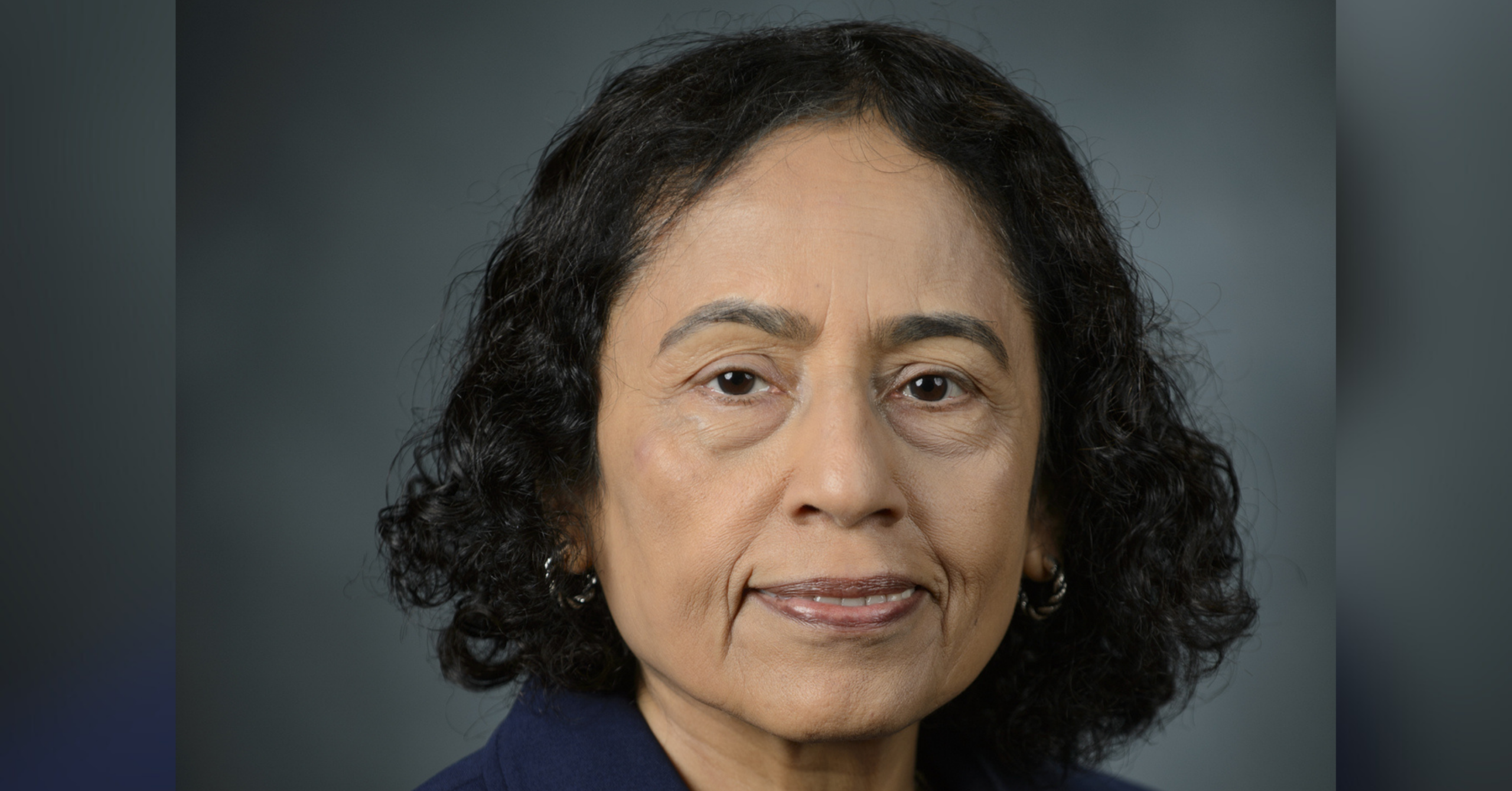 Vishakha Rawool, Ph.D., CCC-A in a professional portrait photo with a green background