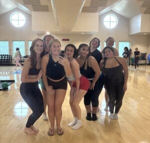 Group of students from a fitness class standing in the gym after a workout.