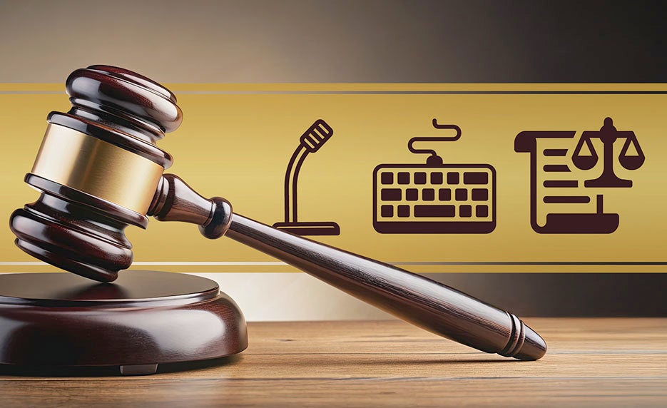 Gavel in the foreground with a yellow banner showing a microphone, keyboard, and legal document with scales behind it.