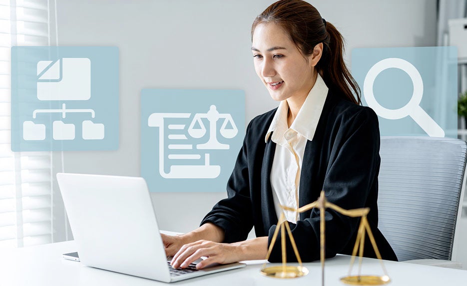 Female lawyer typing on a laptop with scales of justice icons in the background.