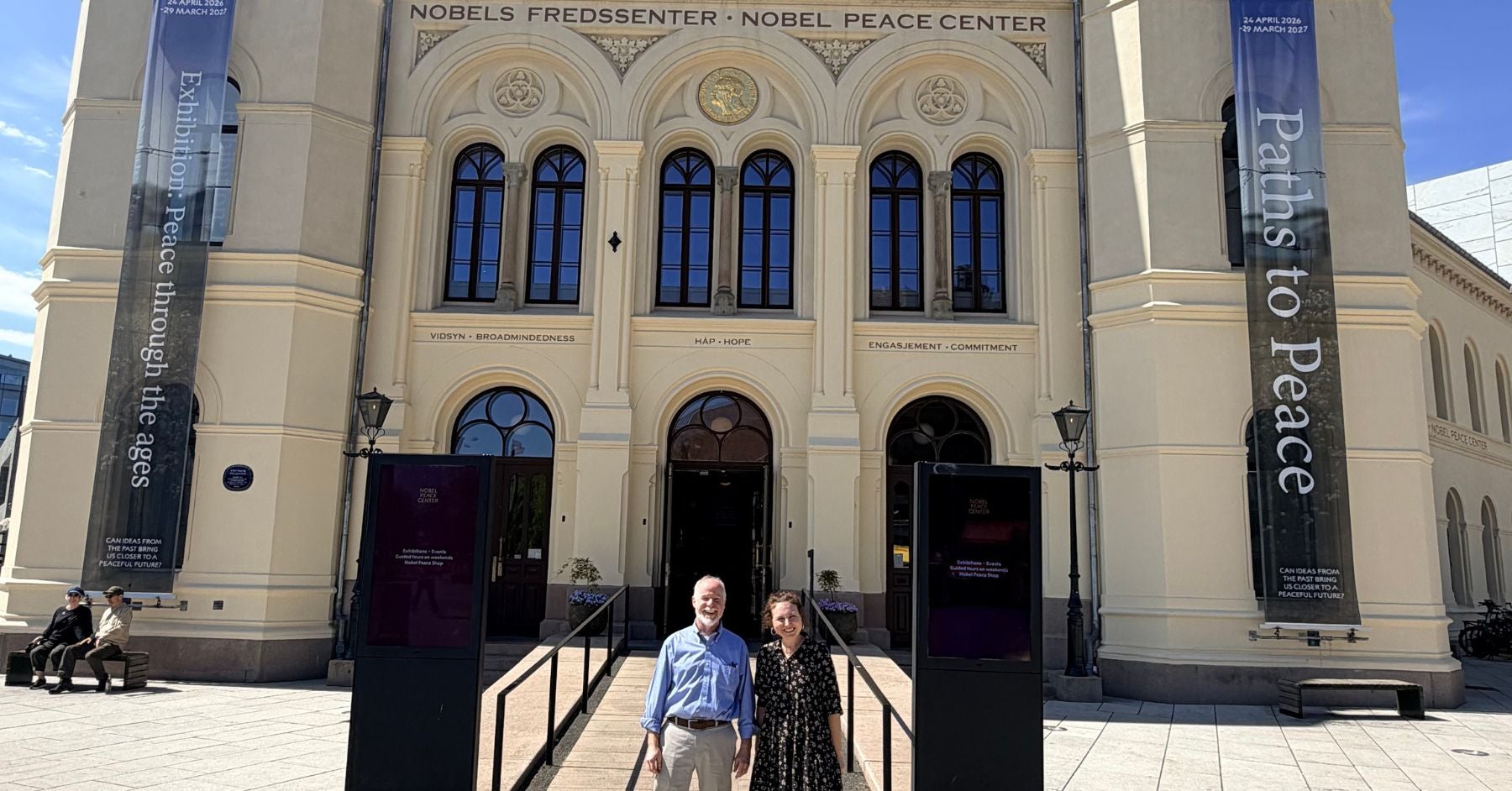 Dr. Steven Engel and Dr. Amy Potter visit Oslo, Norway and stand in front of the Peace Center. They are both happy to be there.