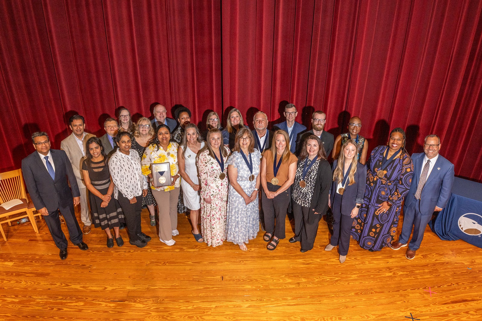 Award winners stand together holding awards at Georgia Southern University Awards of Excellence ceremony