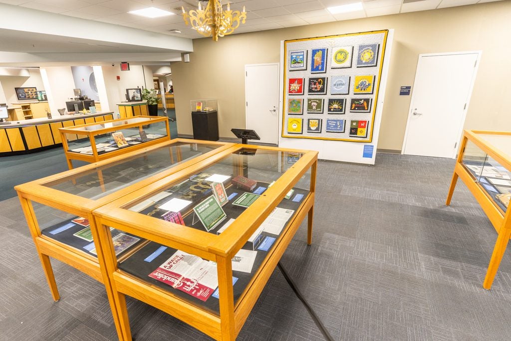 A library exhibit with glass cases with different photos and artificats. 